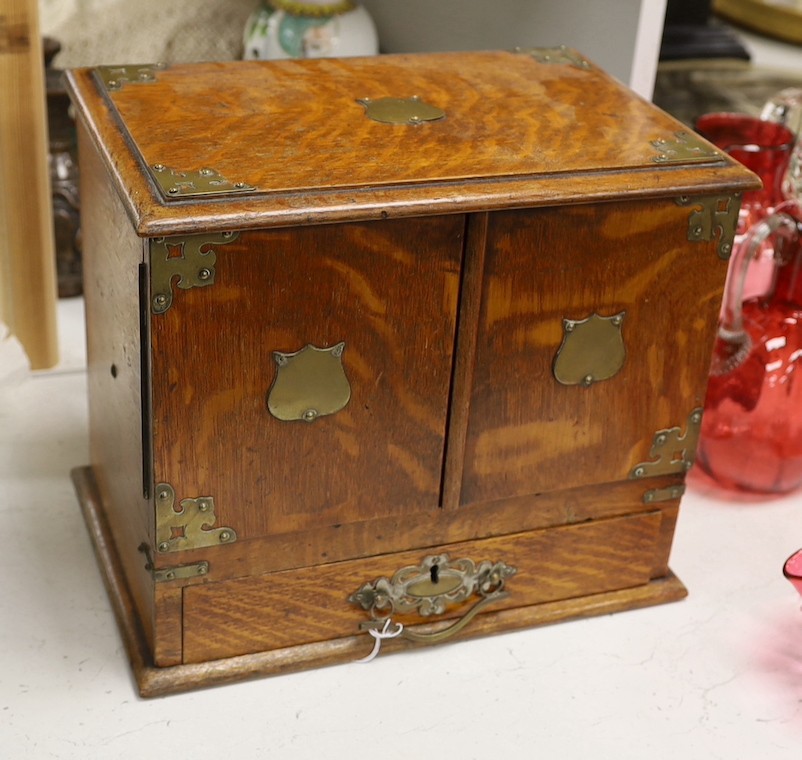 A 19th century oak stationery cabinet with brass mounts, 28.5 cms high x 33cms wide.